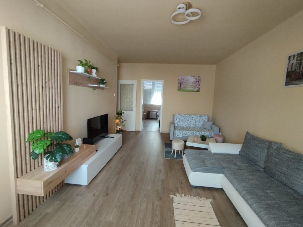 Nappali a tévéfallal, háttérben a hálószoba